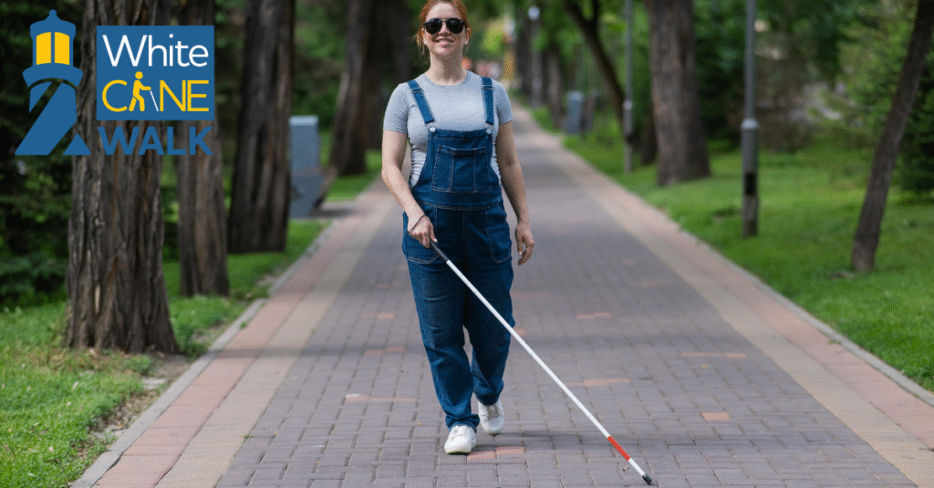 2025 White Cane Walk featured image. Shows a young woman - appearing to be in her mid-20s - wearing overalls and holding a white cane, walking on paved path through a park.